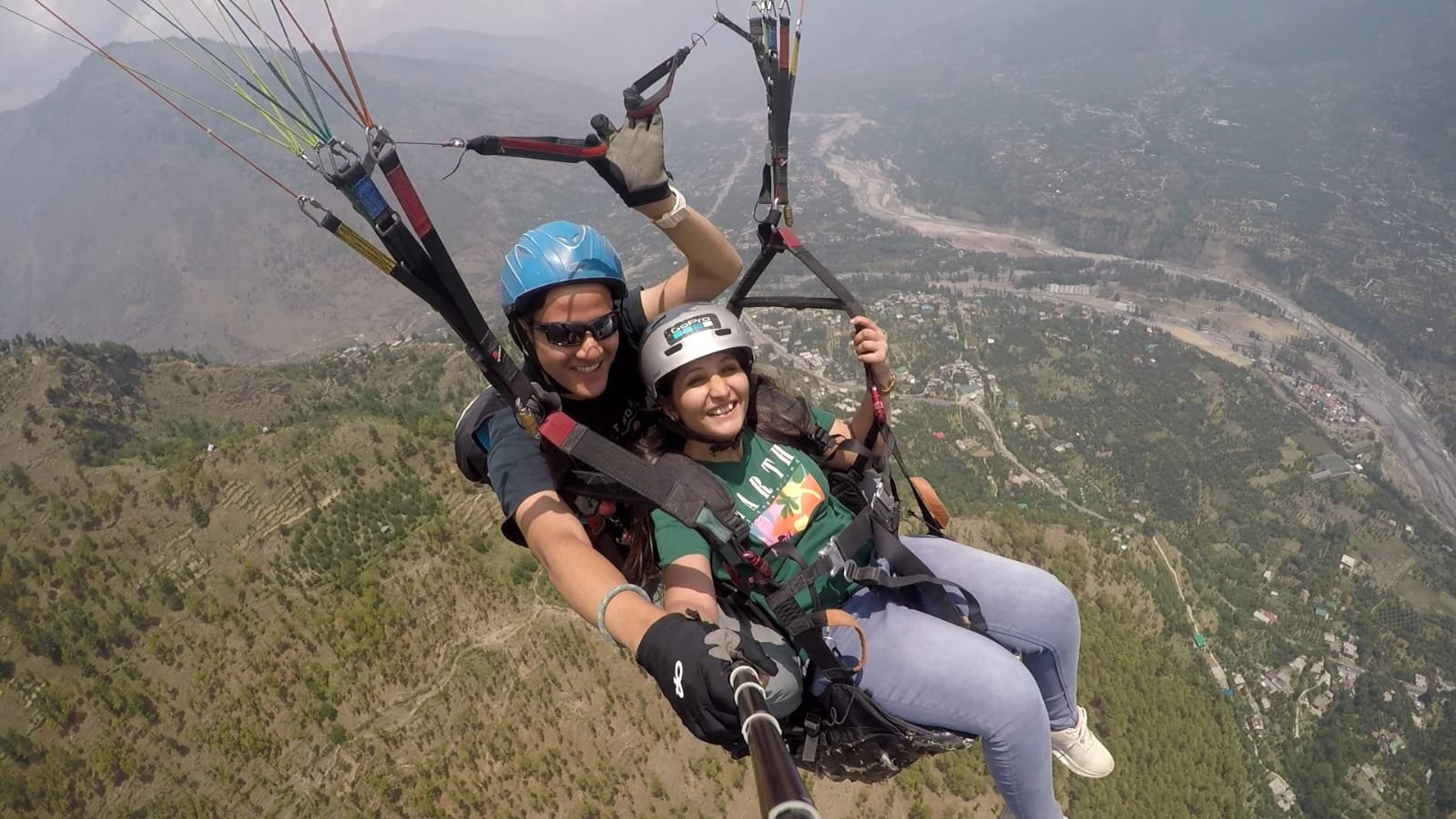 Born To Fly team helping a tandem flyer prepare with a helmet and harness in Dobhi